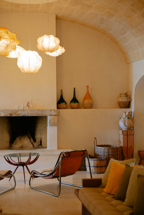 Salotto con camino, volte in pietra e arredi dal design essenziale in stile mediterraneo.
