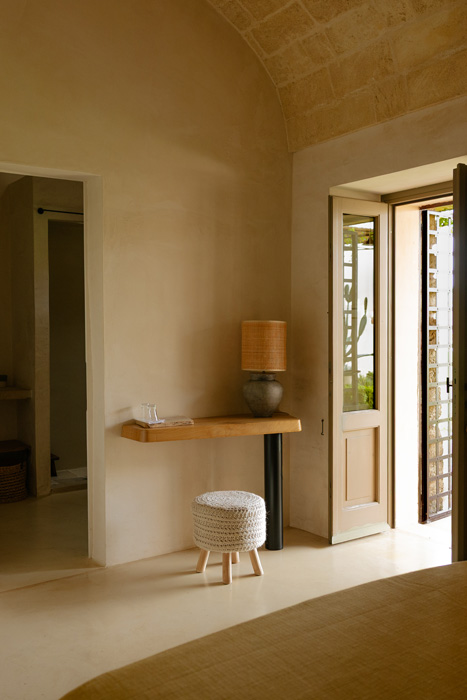 Interno di Junior Suite con volte in pietra, arredi essenziali e luce naturale.