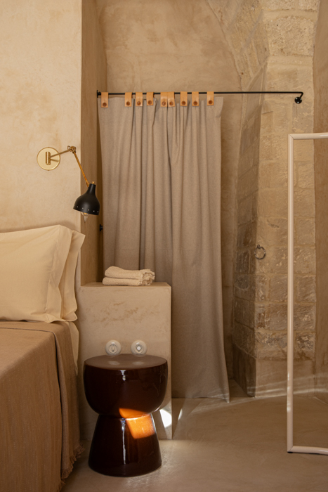 Interno della camera Classic di Le Cinquestanze con dettagli in pietra e arredi minimal.