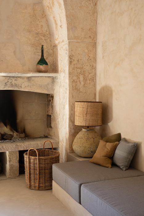 Angolo lounge con camino in pietra e sedute integrate.